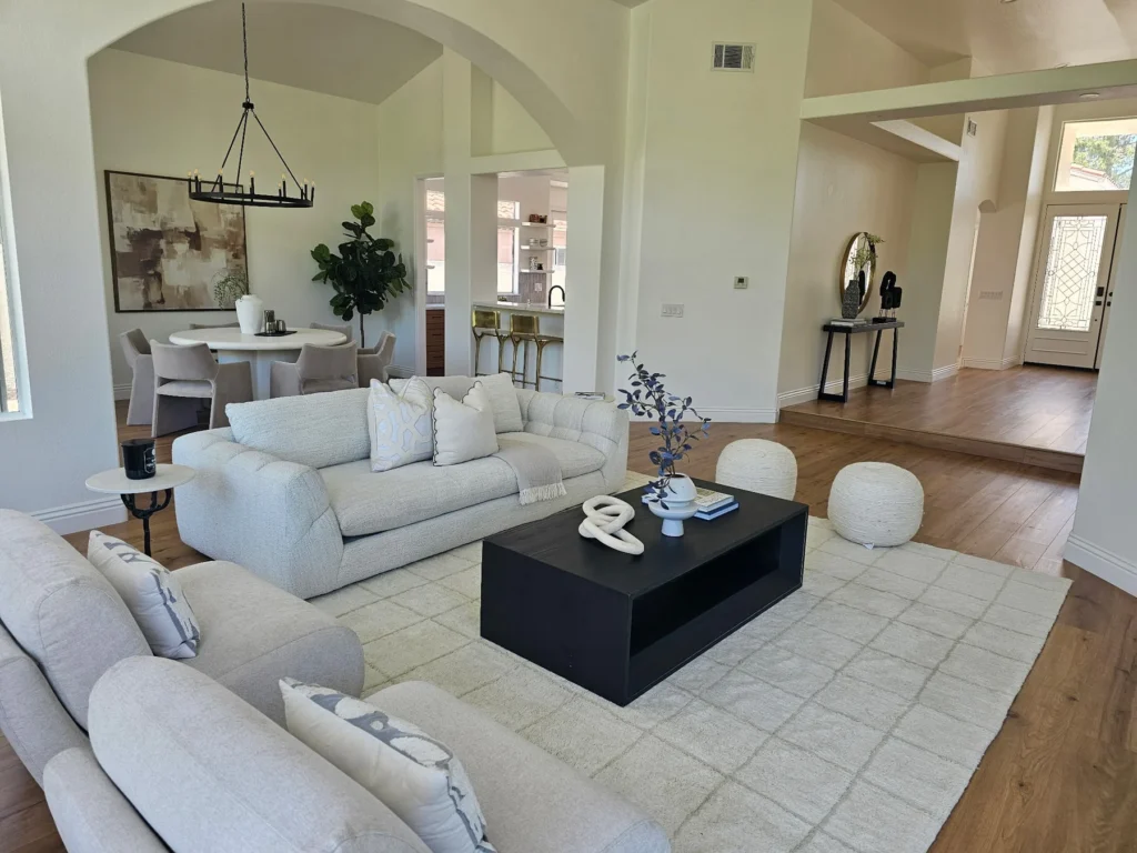 Living and dining areas connected by wide openings and continuous wood flooring.